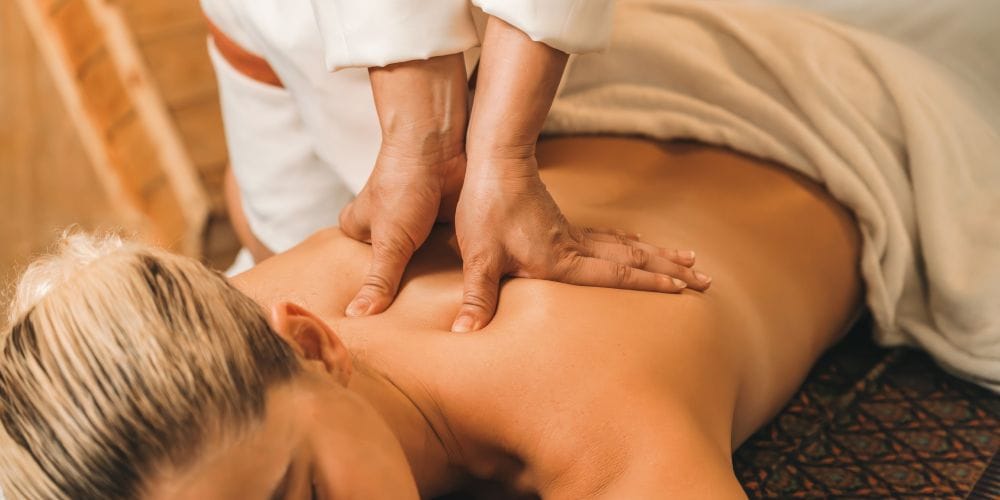 Woman receiving a back massage at a massage studio.